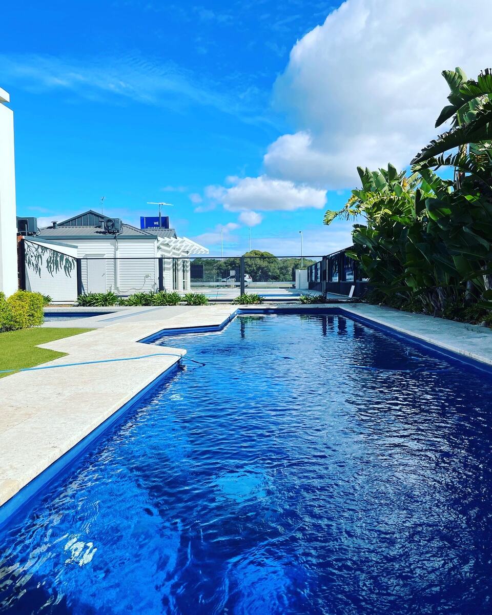 Pure Perf Textured Black fencing around a backyard pool and lawn, Perth